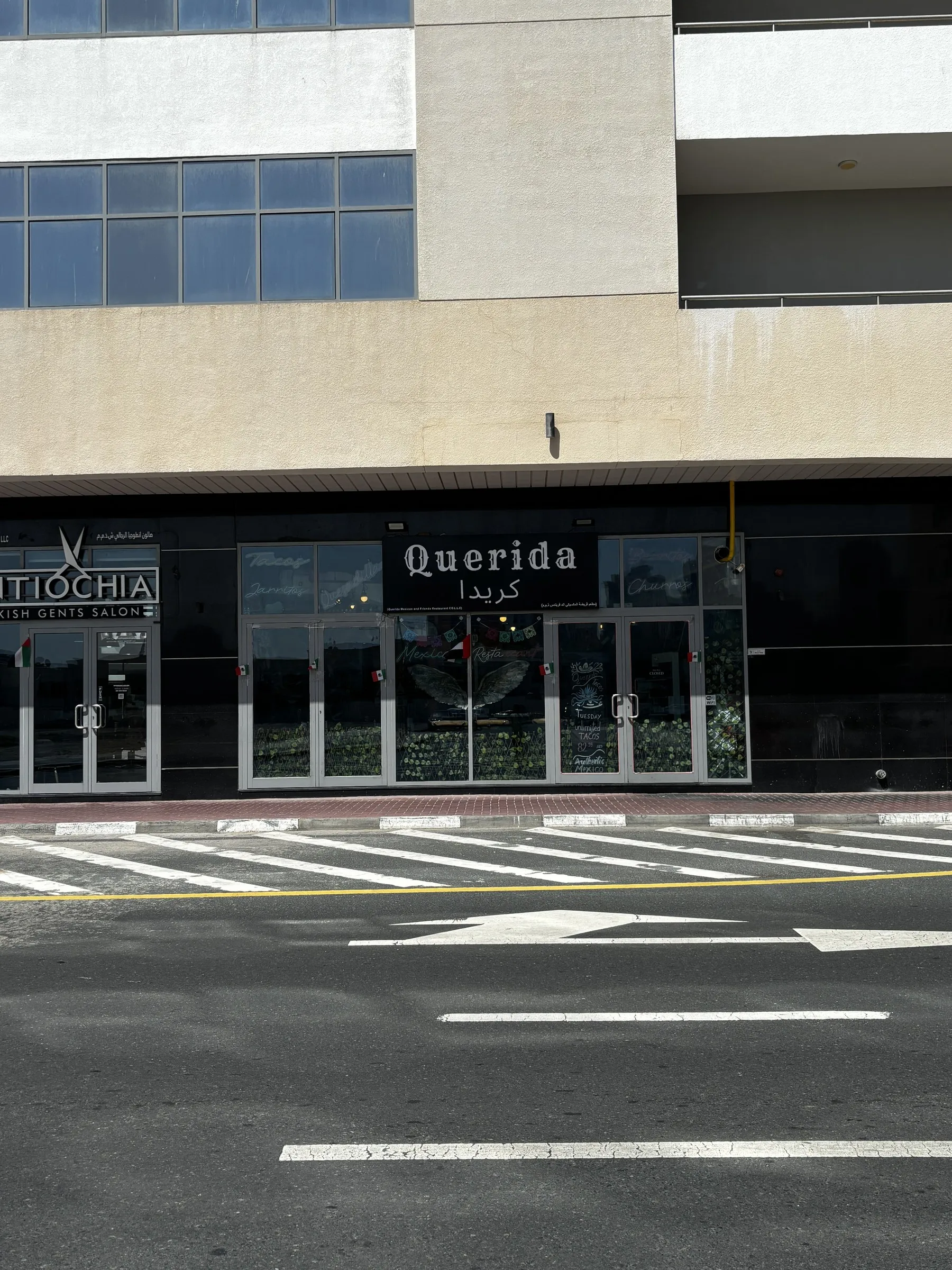 Querida storefront in Al Barsha 1, evening neon glow